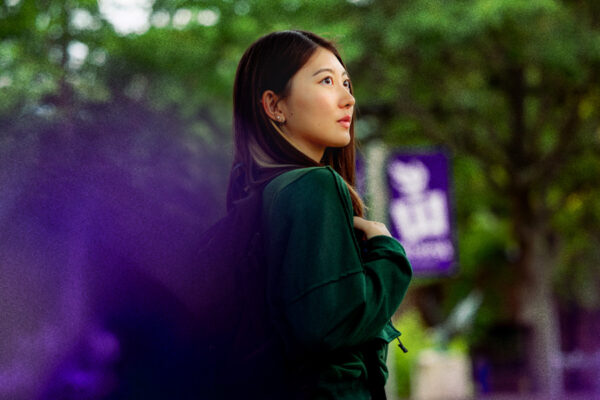 A female student wearing a backpack poses on the WSU campus in Winona.