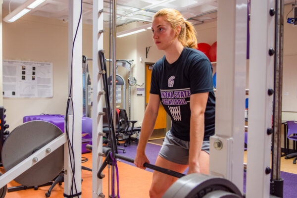 A student lifts weights in an exercise lab in Maxwell Hall.
