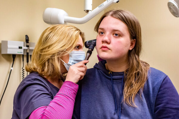 A nurse examines a student's ear during an appointment at Health Services.