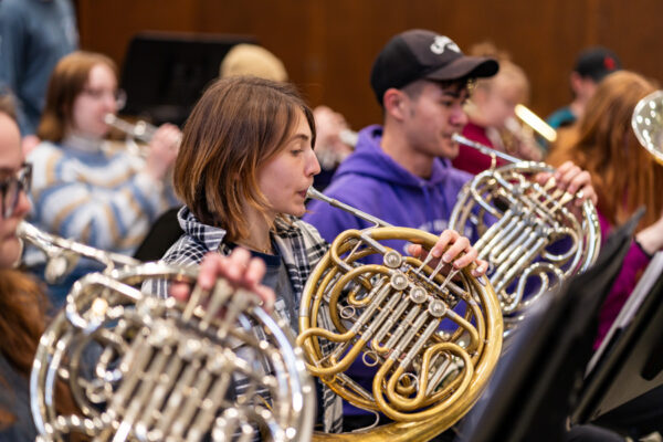 Students play french horns in the WSU symphonic band.