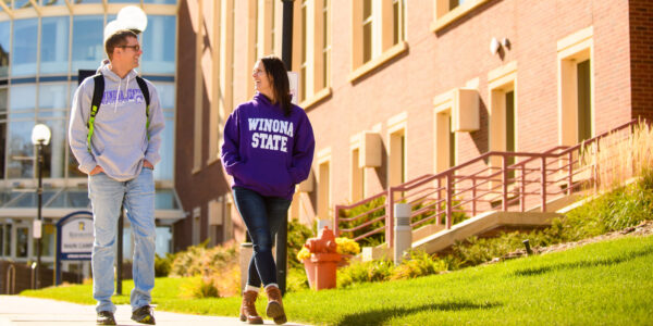 Students walk outside the RCTC main campus on a sunny day in Rochester, MN.