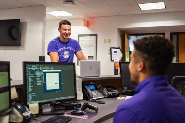 A student worker helps another student in the Technical Support Center in Somsen Hall.