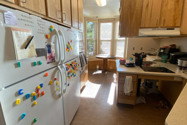 The kitchen in the WSU Sustainability House with fridges, sinks, stoves, and a dining nook.